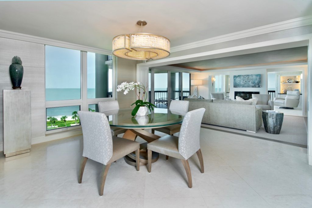 Contemporary Dining room for four with round glass table, round chandelier.