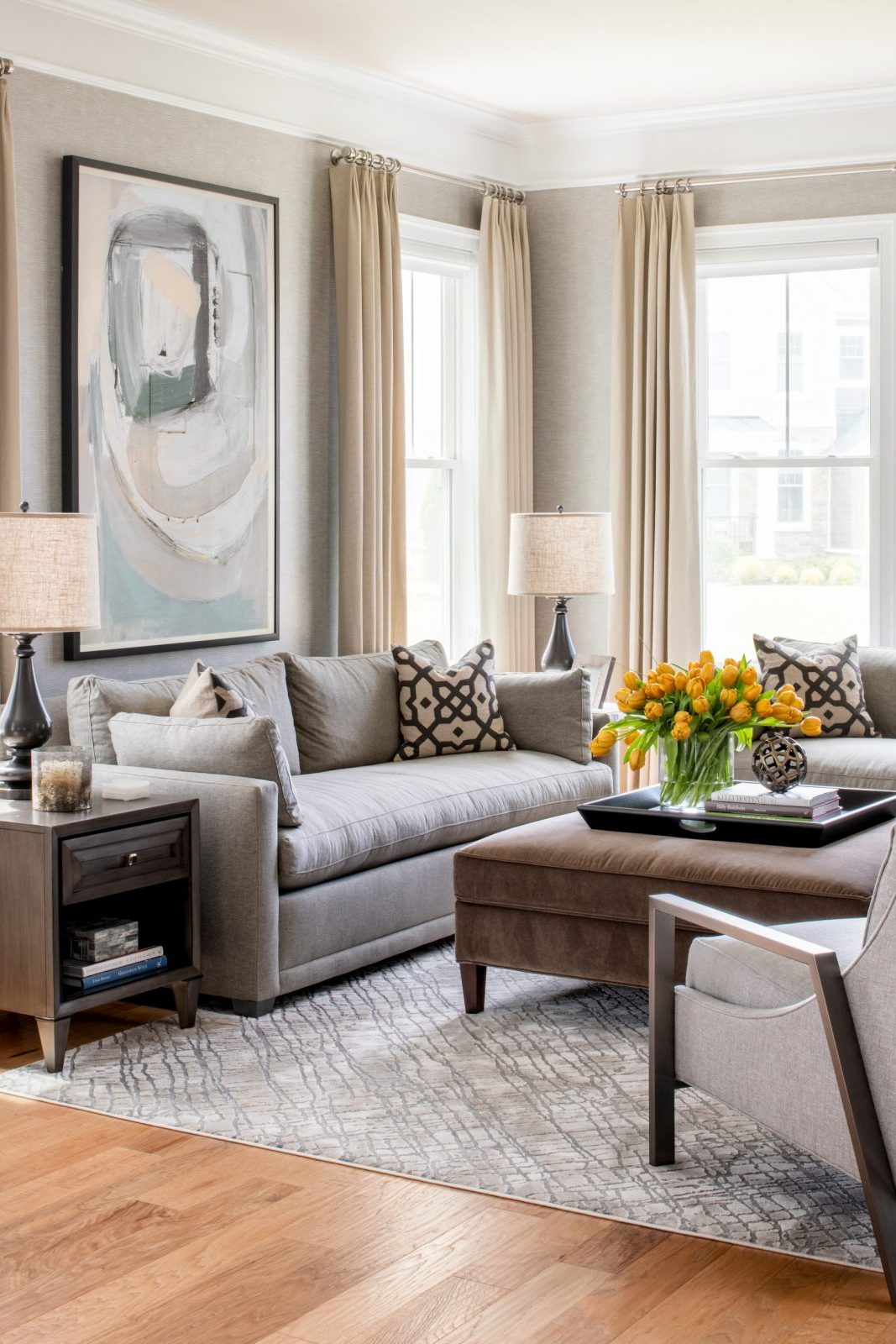 Contemporary living room in shades of grey and pale gold. Contemporary art and gold tulips